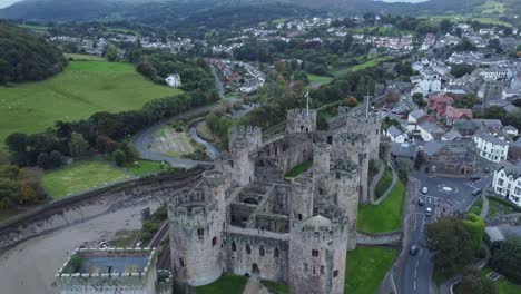 Medieval-Conwy-castle-walled-old-market-town-aerial-view-countryside-reveal