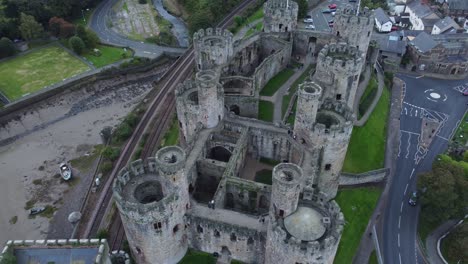 Medieval-Conwy-castle-walled-market-town-landmark-aerial-view-pull-back