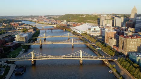 Aerial-view-towards-the-bridges-in-downtown-Pittsburgh,-sunny-evening-in-USA---tilt,-drone-shot