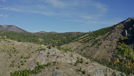 Luftumkreisende-Kleine-Abgelegene-Hütte-Am-Berghang-In-Den-Rocky-Mountains-Im-Herbst,-4k