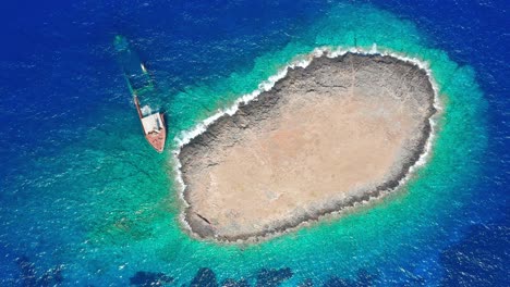 Bird's-eye-view-of-a-shipwreck-beached-with-rocky-island-background