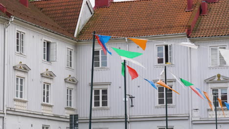 Typical-colorful-flags-blowing-in-the-wind-Gamlestaden,-Gothenburg,-Pan,-Slow-motion