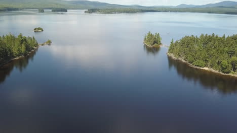 Magnífica-Toma-Aérea-De-Una-Lancha-Rápida-Que-Navega-Por-El-Lago-Rangeley,-Maine