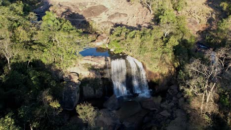 Aerial-drone-revealing-shot-of-tropical-waterfall-in-the-middle-of-the-forest-with-camera-going-backwards