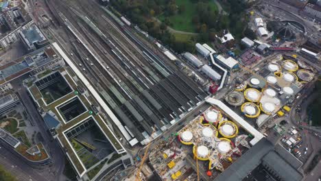 Aerial-of-huge-railroads-and-construction-site-of-main-train-station-Stuttgart-S21-with-cranes-and-construction-worker-in-Stuttgart,-Germany
