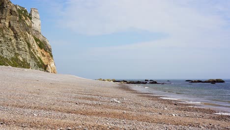 Waves-lap-onto-the-pebble-beach-at-Branscombe-in-Devon-with-the-chalk-cliffs-behind