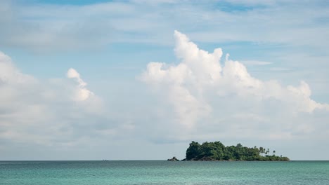 Zeitraffer-Einer-Statischen-Aufnahme-Mit-Sich-Schnell-Bewegenden-Kumuluswolken,-Die-Sich-Von-Links-Nach-Rechts-über-Den-Blauen-Himmel-Bewegen,-Mit-Einer-Dünnen-Oberen-Schicht-Sich-Bewegender-Cirruswolken-über-Einer-Kleinen-Insel-Im-Tropischen-Thailand