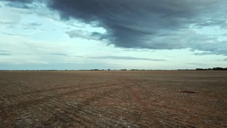 Rising-drone-footage-across-dry-paddock-near-Berriwillock,-Victoria,-Australia,-May-2021