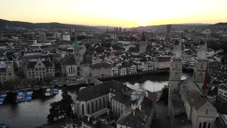 Aerial-view-of-downtown-Zurich,-Switzerland-as-seen-from-behind-the-Grossmünster-church-at-sunset