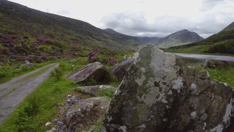 Closeup-footage-on-large-boulders-with-opening-on-rural-road-in-mountain-valley-during-June