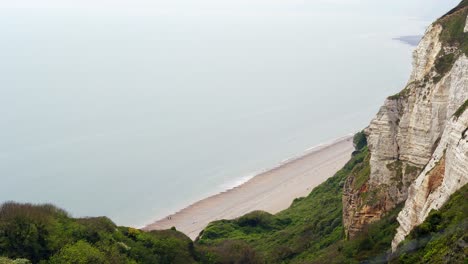 View-from-a-cliff-top-looking-down-over-chalk-cliffs-toward-the-pebble-beach-of-Branscombe-in-Devon,-England