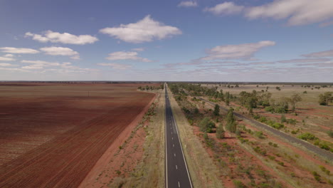 Ein-Einsames-Fahrzeug-Fährt-Von-Einem-Endlosen-Horizont-Aus-Einen-Highway-Im-Australischen-Outback-Hinunter