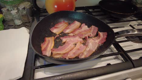 thick-cut-bacon-sizzling-in-a-hot-skillet-on-a-gas-stove-in-grandma's-kitchen