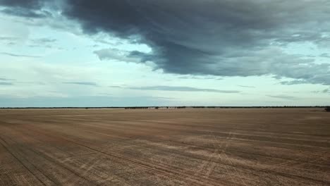 Drone-flight-rising-across-dry-paddock-near-Berriwillock,-Victoria,-Australia,-May-2021