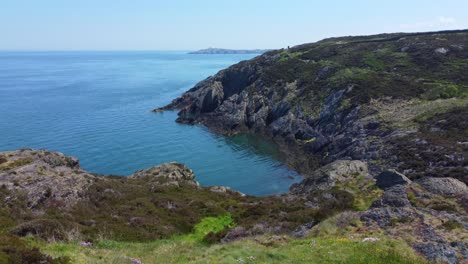 Peaceful-Amlwch-Anglesey-North-Wales-rugged-mountain-coastal-walk-aerial-low-to-high-view