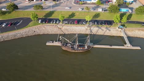 Aerial-boomerang-shot-of-the-Pinta-replica,-revealing-the-Cumberland-River-and-Clarksville,-Tennessee