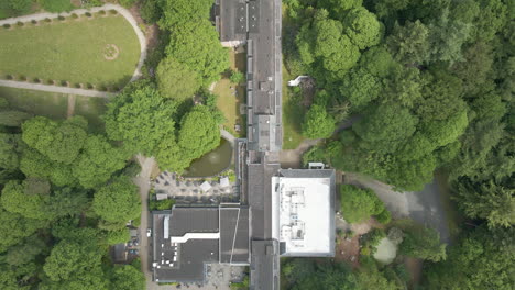 Top-down-Aerial-of-beautiful-hotel-and-conference-center-in-the-middle-of-green-forest