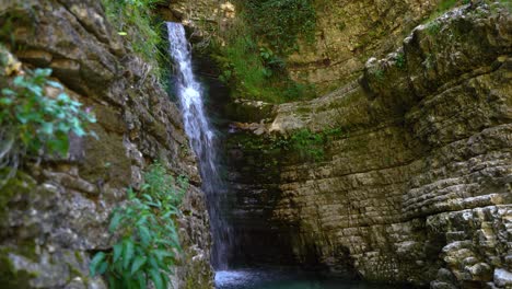 Peaceful-hidden-spot-inside-canyon-with-waterfall-water-splashing-on-rocks-in-Albania
