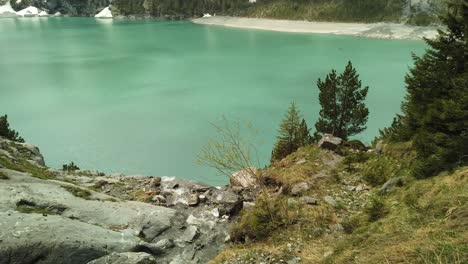 Peaceful-alpine-river-flows-into-the-turquoise-Oeschinensee-in-Switzerland