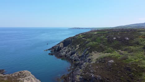 Peaceful-Amlwch-Anglesey-North-Wales-rugged-mountain-coastal-walk-aerial-view-dolly-left-fast