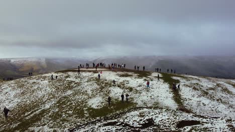 Aerial-view,-panning-Mam-Tor-in-Peak-District-England-summit-in-Winter-snow-storm