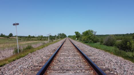 Point-of-view-from-the-front-of-a-train-travelling-down-the-train-tracks-in-the-summertime