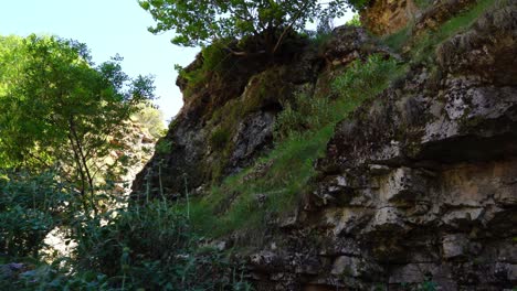 Hiking-on-mountain-slope-with-rocks-and-green-vegetation,-climbing-outdoor-in-Albania