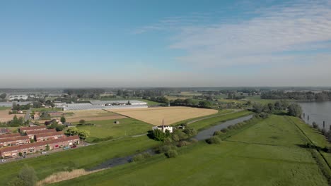 Aerial-approach-to-former-laundromat-industrial-laundry-business-building-with-large-pipe-in-Dutch-floodplains-river-IJssel-landscape-near-Zutphen,-The-Netherlands