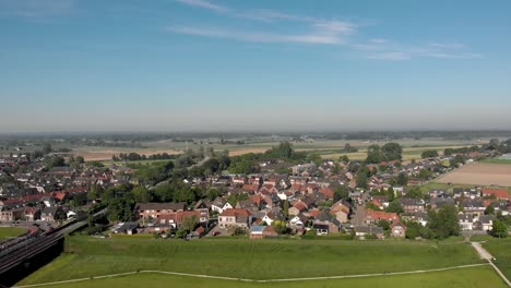 Luftstadtbild-Von-De-Hoven-über-Den-Fluss-Ijssel-In-Zutphen,-Niederlande,-Vor-Blauem-Himmel-Mit-Überschwemmungsgebieten-Im-Vordergrund