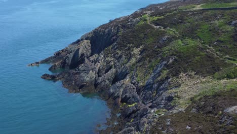 Peaceful-Amlwch-Anglesey-North-Wales-rugged-mountain-coastal-walk-aerial-view-tilt-up-landscape-reveal