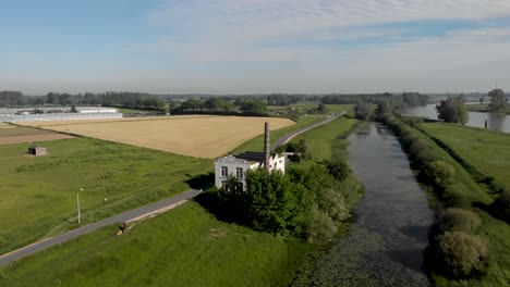 Aerial-view-of-IJsselstroom-former-industrial-water-management-building-revealing-wider-surrounding-at-the-river-IJssel-riverbed-and-floodplains-with-greenhouses-and-De-Hoven-neighbourhood-in-Zutphen