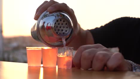 Pouring-shots-outdoors-against-a-sunset-backdrop