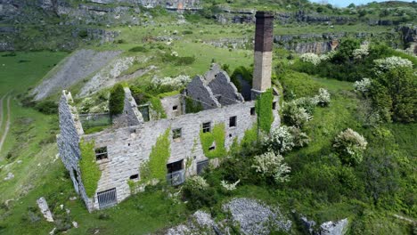 Abandoned-overgrown-ivy-covered-desolate-countryside-historical-Welsh-coastal-brick-factory-mill-aerial-view-rising-right-orbit