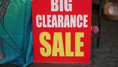 Big-clearance-sale-bright-red-white-and-yellow-sign-in-small-local-business-department-store-shop-in-mall-during-retail-apocalypse