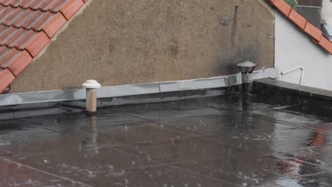 Close-shot-of-a-roof-deck-in-a-suburban-neighborhood-during-hard-rain-fall