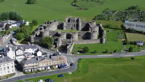 Sunny-touristic-Beaumaris-castle-town-aerial-view-ancient-Anglesey-fortress-landmark-zoom-in-fast