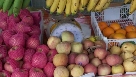 Frisches-Obst-An-Einem-Marktstand-Mit-äpfeln-Und-Hängenden-Bananen-In-Thailand-Mit-Langsam-Herausziehendem-Zoom