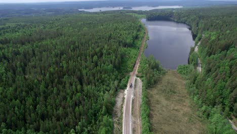 Remote-Rural-Construction-Of-Railway-Next-To-Lake-And-Boreal-Forest,-Aerial