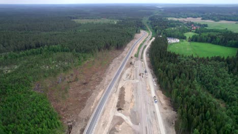 Railroad-Track-Construction-And-Dirt-Road-In-Boreal-Forest,-Sweden,-Aerial-Top