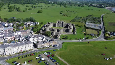 Sunny-touristic-Beaumaris-castle-town-aerial-slow-descending-view-ancient-Anglesey-fortress-landmark