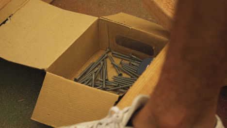 Picking-up-wood-screw-from-box,-Close-Up