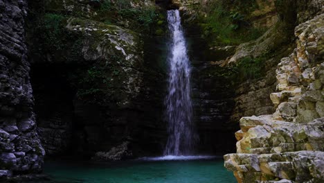 Beautiful-waterfall-inside-canyon,-water-falling-into-clean-turquoise-pound-in-Progonat,-Albania
