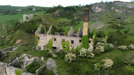 Abandoned-overgrown-ivy-covered-desolate-countryside-historical-Welsh-coastal-brick-factory-mill-aerial-view-fast-orbit-to-left-front