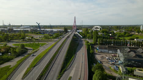 Aerial---Cars-Moving-Along-the-Highway-Road-Through-Third-Millennium-John-Paul-bridge,-cargo-terminal-on-background,-Gdansk-Poland-on-sunny-day