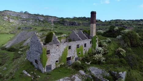 Abandoned-overgrown-ivy-covered-desolate-countryside-historical-Welsh-coastal-brick-factory-mill-aerial-view-mid-orbit-right