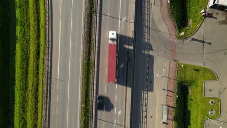 Freight-Trucks-and-cars-driving-along-the-highway-daytime-aerial-top-down-view,-Gdansk-Poland