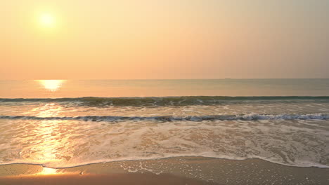 Kleine-Meereswellen-An-Einem-Sandstrand-Mit-Sonnenuntergang