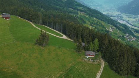 Aerial-drone-flight-at-scenic-Zillertal-skiing-sport-hiking-and-trekking-vacation-mountain-valley-along-cottages,-lodges-and-trees-in-nature-in-the-Austrian-Bavarian-alps-on-a-sunny-lush-summer-day