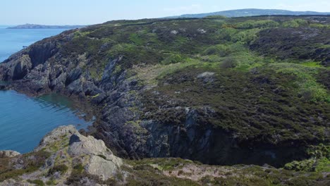 Peaceful-Amlwch-Anglesey-North-Wales-rugged-mountain-coastal-walk-aerial-view-flyover-forward-tilt-down