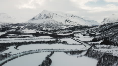 Luftaufnahme-Des-Zugefrorenen-Flusses-Mit-Schneebedeckten-Feldern-Und-Bergen-In-Narvik,-Norwegen